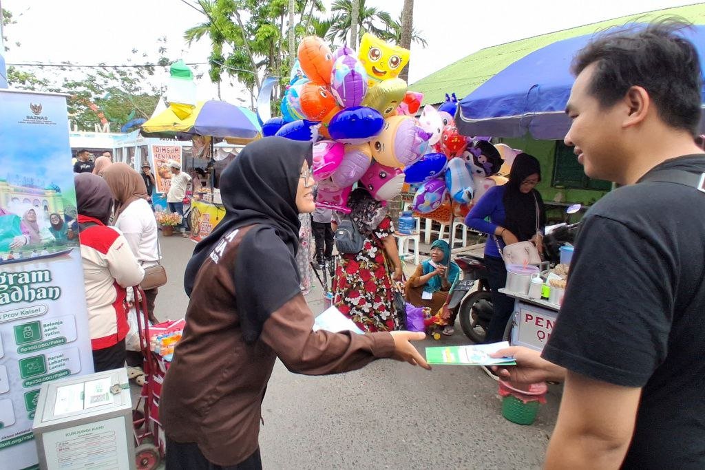Mahasiswa Penerima Beasiswa BAZNAS Kalsel Ajak Masyarakat Berzakat di Stan National Halal Fair Pasar Wadai Banjarmasin